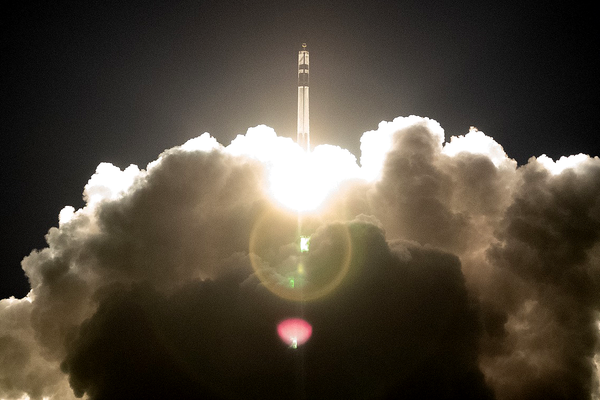 Rocket lifting off and surrounded by plumes of exhaust